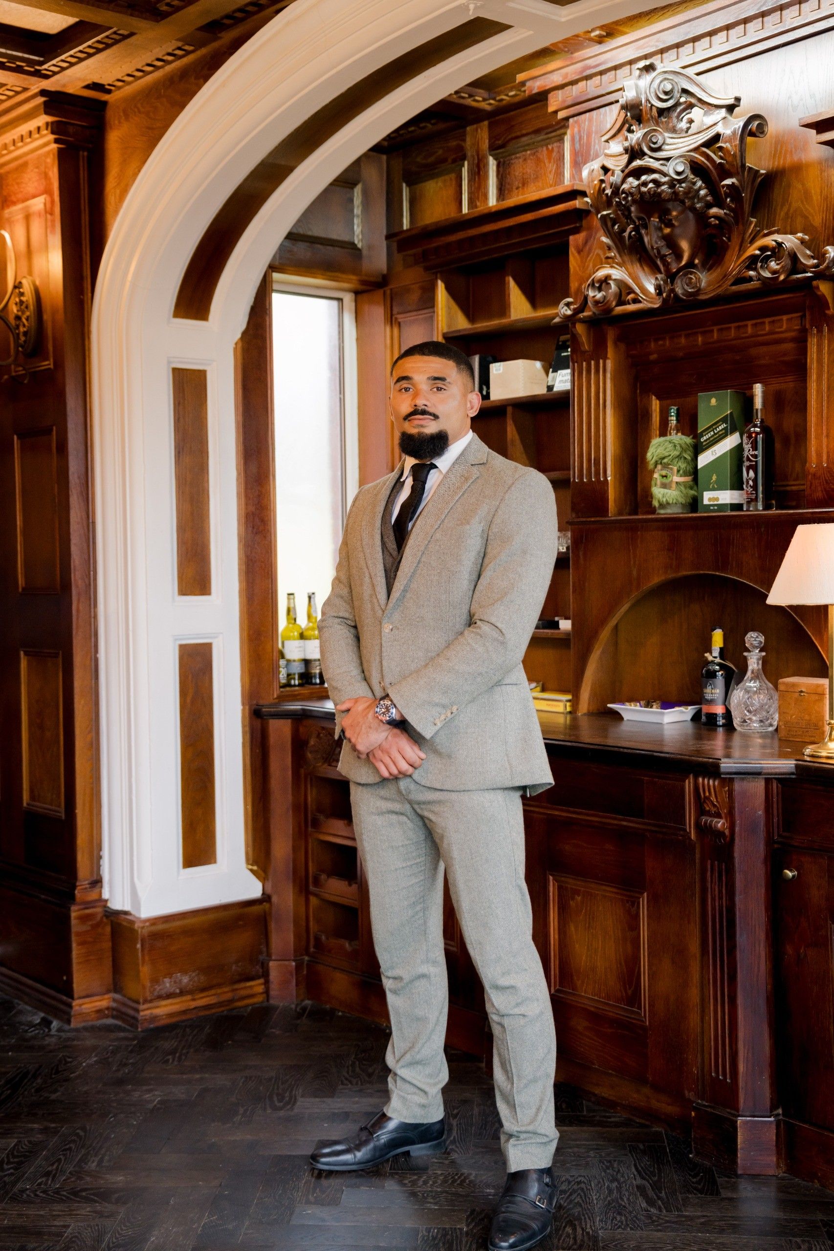 Joe, your KMLets property manager, standing in a wood-panelled office in a linen suit